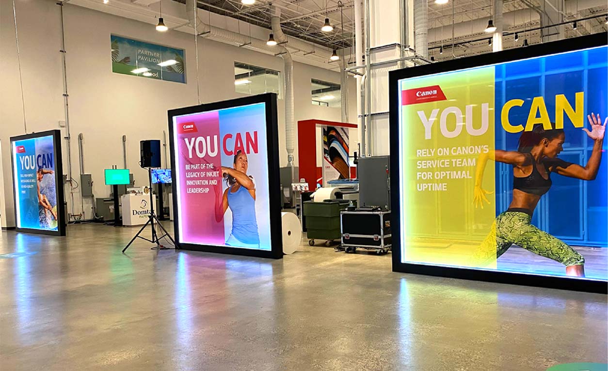 three display signs showing a woman running, a woman playing tennis, and a man surfing