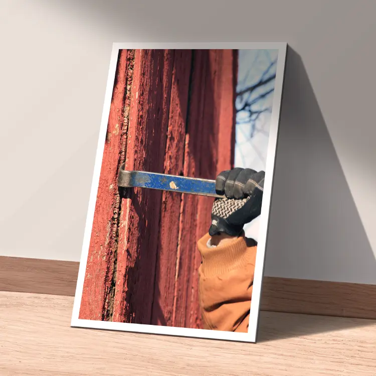 A photo of someone taking apart red barn wood showing how they get their sustainable wood for Lake County Barnwood